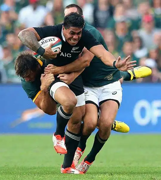 Rugby: Il giocatore degli All Blacks Malakai Fekitoa placcato da due giocatori del Sudafrica durante una partita del Championship disputata a Johannesburg e vinta 27-25 dagli africani.