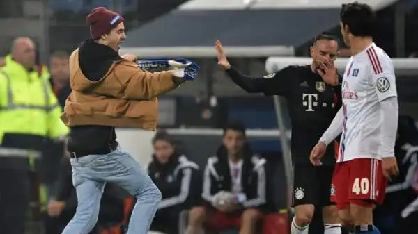 Il Bayern ha vinto ad Amburgo per 3-1 ma la notizia è l'invasione di campo da parte di un tifoso avversario che ha colpito con la sciarpa e insultato con tanto di dito medio Franck Ribery.
