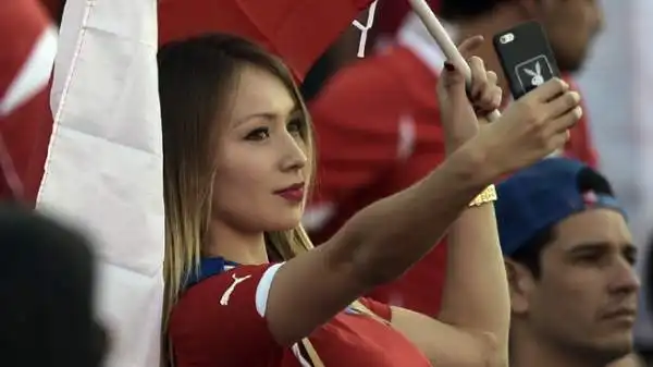 Atmosfera bollente all'Estadio Nacional durante la finalissima di Copa America. Le tifose danno spettacolo sugli spalti.