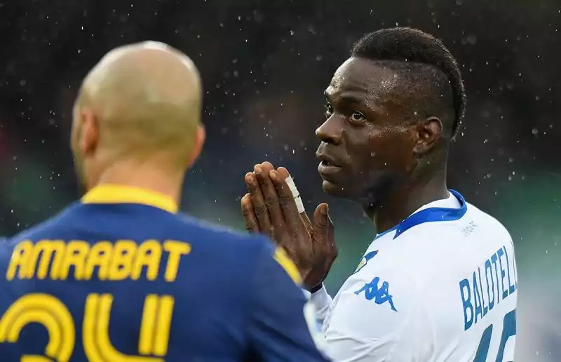 Mario Balotelli minaccia di uscire dal campo dopo essere stato vittima di cori razzisti durante Verona-Brescia: SuperMario in preda alla rabbia calcia un pallone in tribuna.