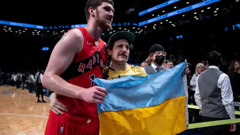 In NBA Svi Mykhailiuk ha posato con un tifoso e una bandiera ucraina nella sfida tra Toronto Raptors e Brooklyn Nets