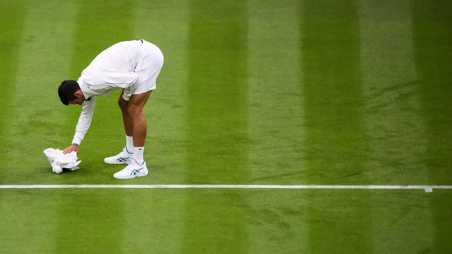 Ecco il tennista mentre cerca di asciugare il campo con la sua salvietta