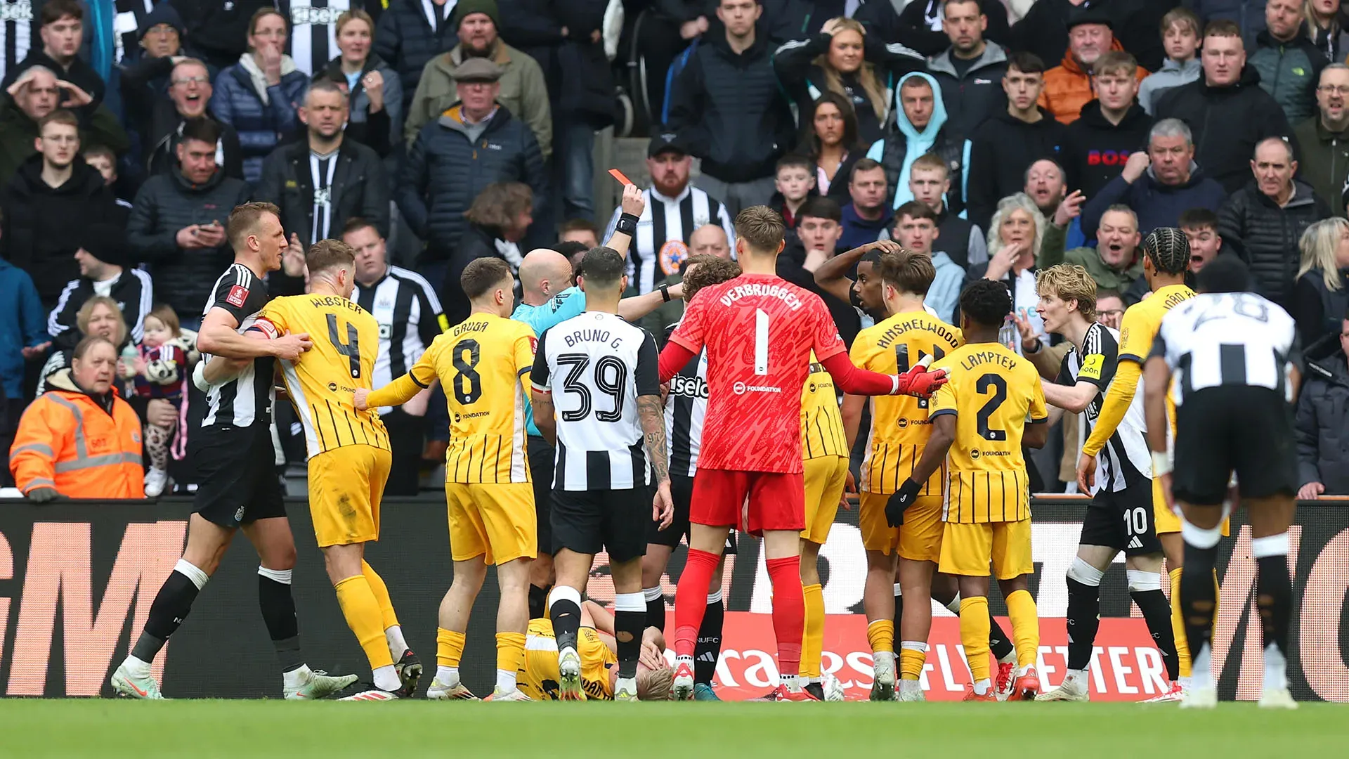 Calciatori di entrambe le squadre si sono precipitate dal direttore di gara